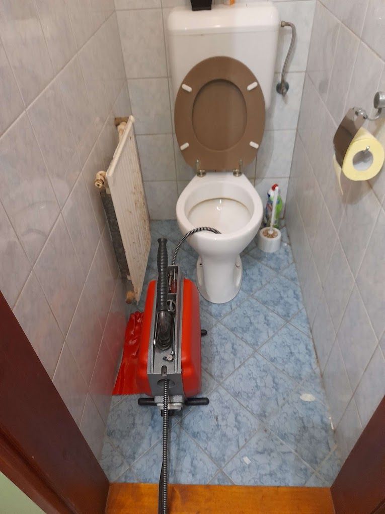 Spirálos gép a WC előtt, a spirál a WC-be vezetve